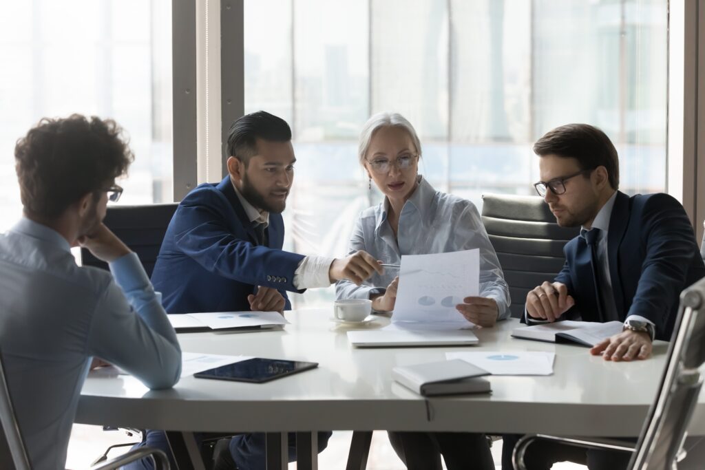 Business team sitting around a conference table discussing.