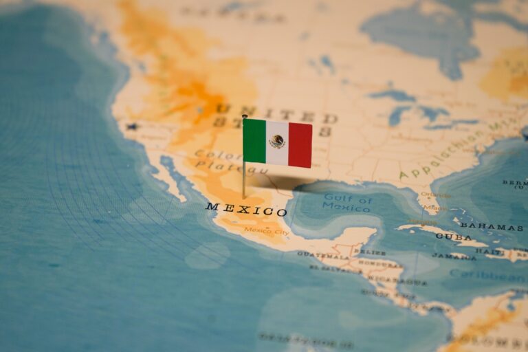 Small Mexican flag pinned on a map.
