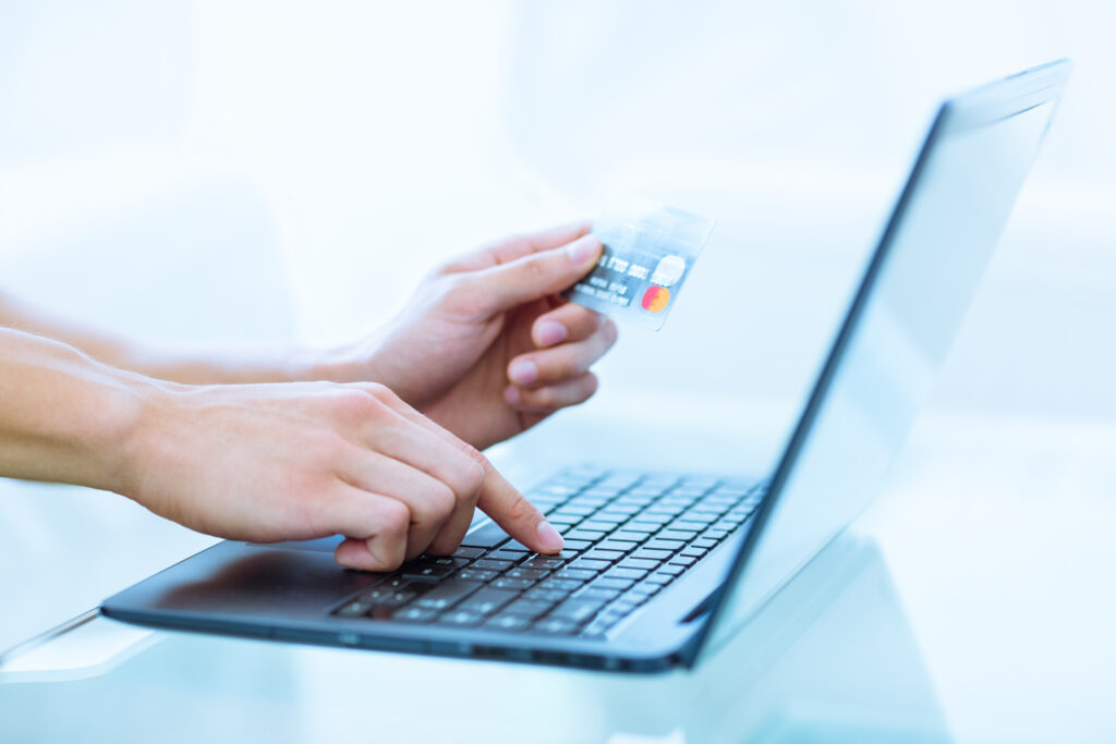 A person using Master Card to buy online through a laptop.